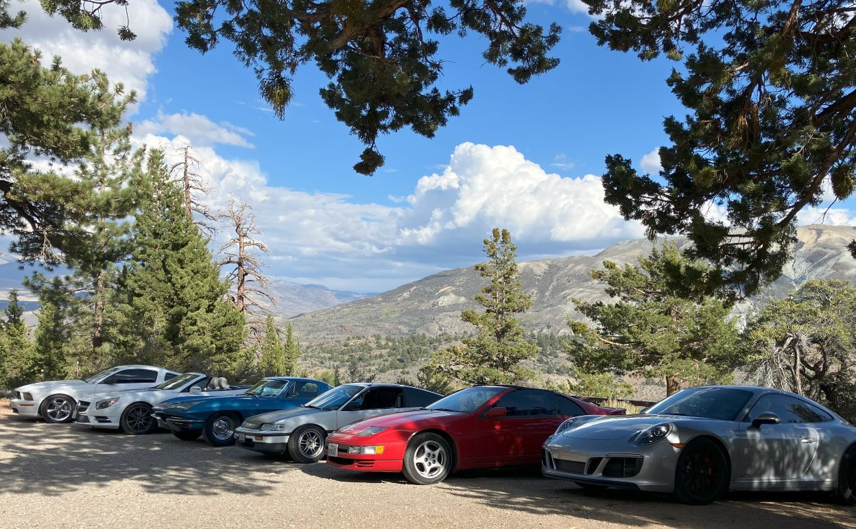 Car club vehicles parked near mountain overlook